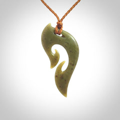 This photo shows a koru pendant carved from New Zealand Jade. We provide this piece with an adjustable gingernut brown coloured cord.