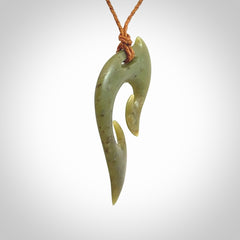 This photo shows a koru pendant carved from New Zealand Jade. We provide this piece with an adjustable gingernut brown coloured cord.