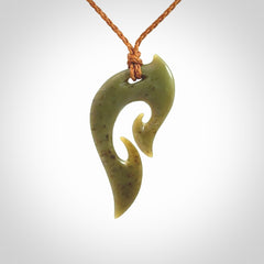 This photo shows a koru pendant carved from New Zealand Jade. We provide this piece with an adjustable gingernut brown coloured cord.