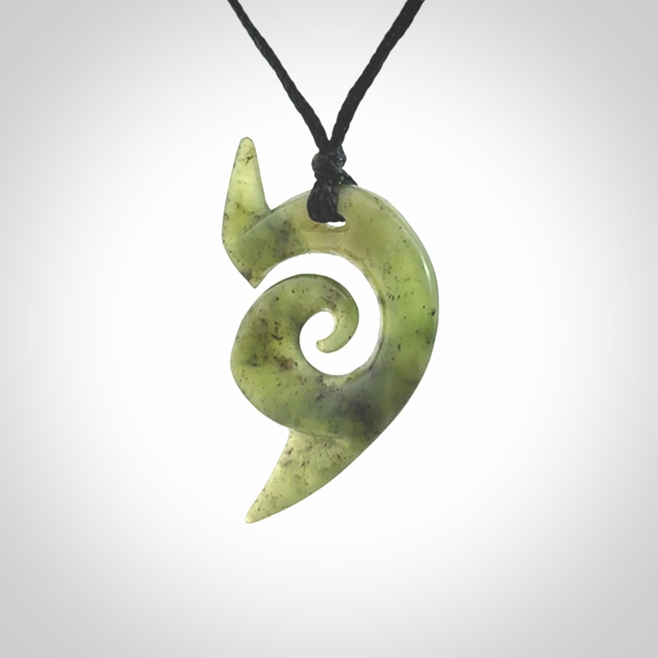 This photo shows a koru pendant carved from New Zealand Jade. The artist, Shaun Gardiner, has carved this beautifully. We provide this piece with an adjustable black cord. This is a fantastic work of art, we have one only.