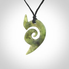 This photo shows a koru pendant carved from New Zealand Jade. The artist, Shaun Gardiner, has carved this beautifully. We provide this piece with an adjustable black cord. This is a fantastic work of art, we have one only.