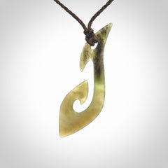 This photo shows a large contemporary matau pendant carved from New Zealand Jade. The artist, Shaun Gardiner, has carved this beautifully. We provide this piece with an adjustable dark brown coloured cord. This is a fantastic work of art, we have one only.