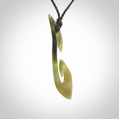 This photo shows a large contemporary matau pendant carved from New Zealand Jade. The artist, Shaun Gardiner, has carved this beautifully. We provide this piece with an adjustable dark brown coloured cord. This is a fantastic work of art, we have one only.