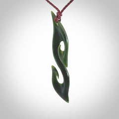 This photo shows a contemporary S shaped pendant carved from New Zealand Jade. The artist, Shaun Gardiner, has carved this beautifully. We provide this piece with an adjustable plum cord. This is a fantastic work of art, we have one only.