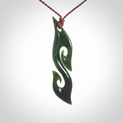 This photo shows a contemporary S shaped pendant carved from New Zealand Jade. The artist, Shaun Gardiner, has carved this beautifully. We provide this piece with an adjustable plum cord. This is a fantastic work of art, we have one only.