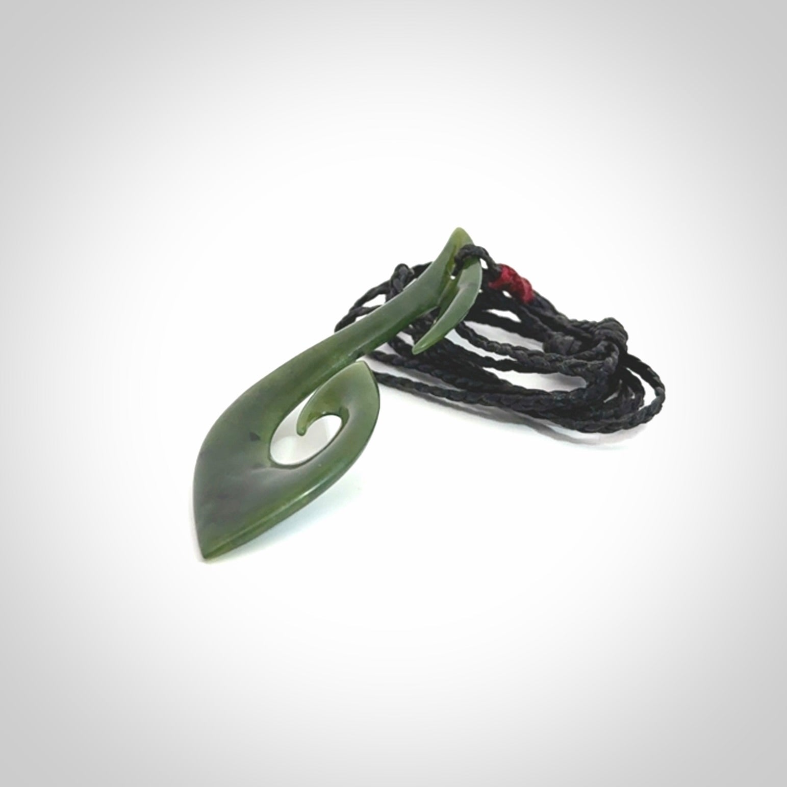 This photo shows a large hook with koru pendant carved from New Zealand Jade. We provide this piece with an adjustable black cord.