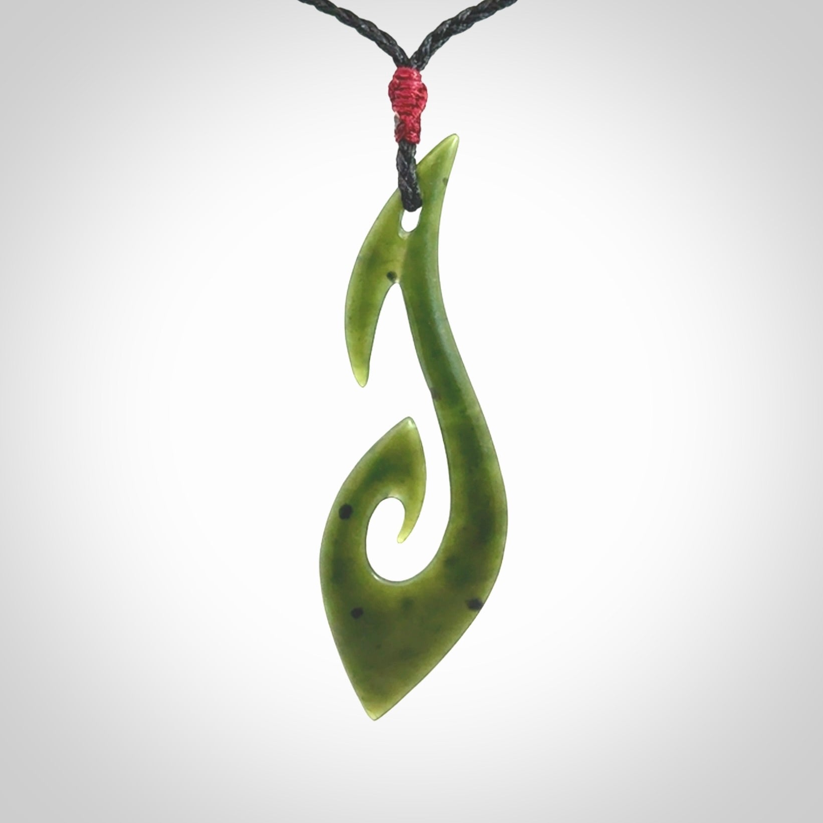 This photo shows a large hook with koru pendant carved from New Zealand Jade. We provide this piece with an adjustable black cord.