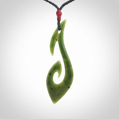This photo shows a large hook with koru pendant carved from New Zealand Jade. We provide this piece with an adjustable black cord.