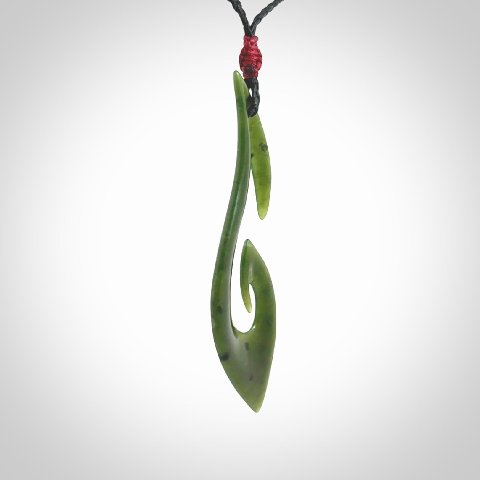 This photo shows a large hook with koru pendant carved from New Zealand Jade. We provide this piece with an adjustable black cord.