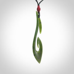 This photo shows a large hook with koru pendant carved from New Zealand Jade. We provide this piece with an adjustable black cord.