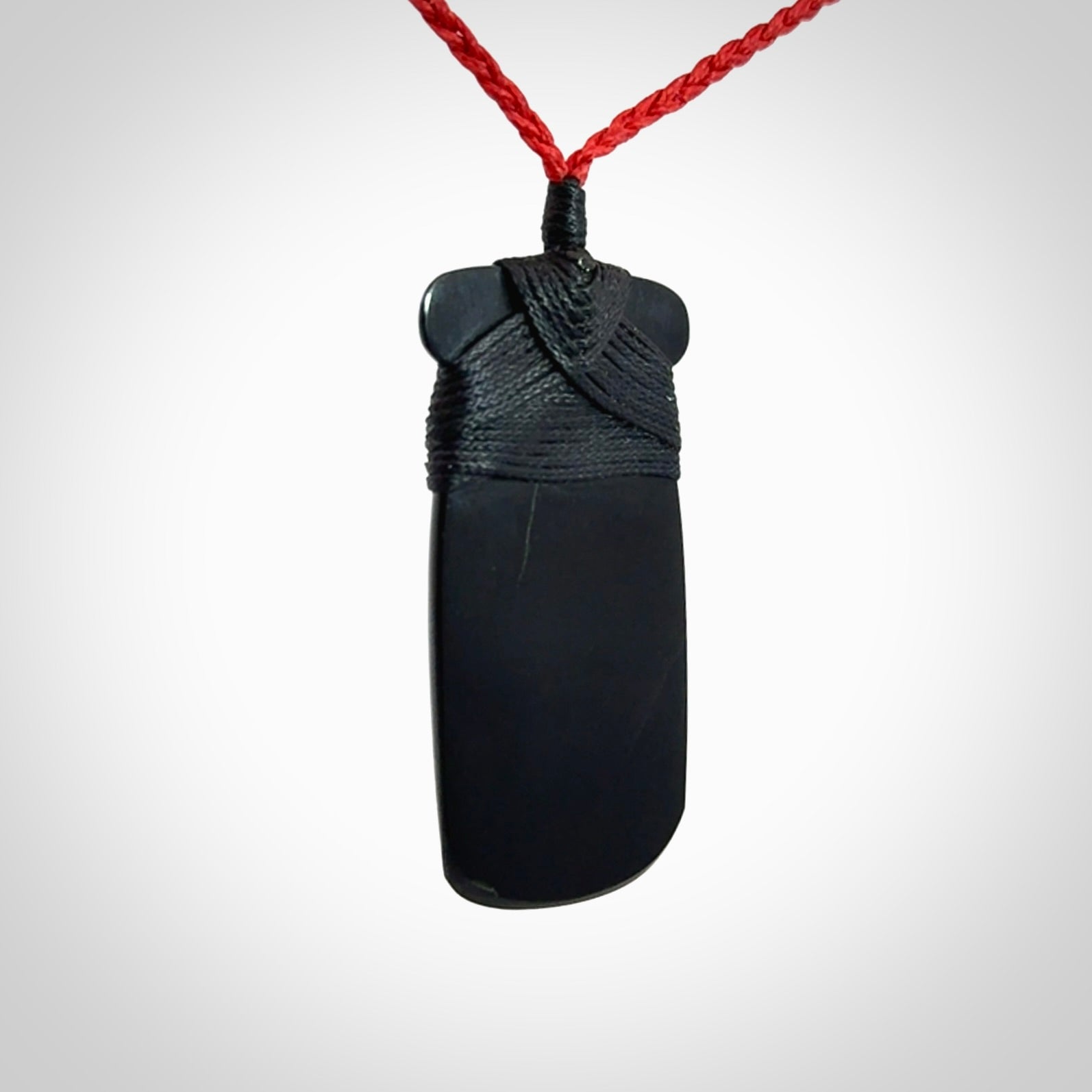 Hand carved black jade toki pendant. Made by NZ Pacific from Australian black jade. Black Jade Toki provided with adjustable cords and packaged in a woven kete pouch. Delivered with express courier.