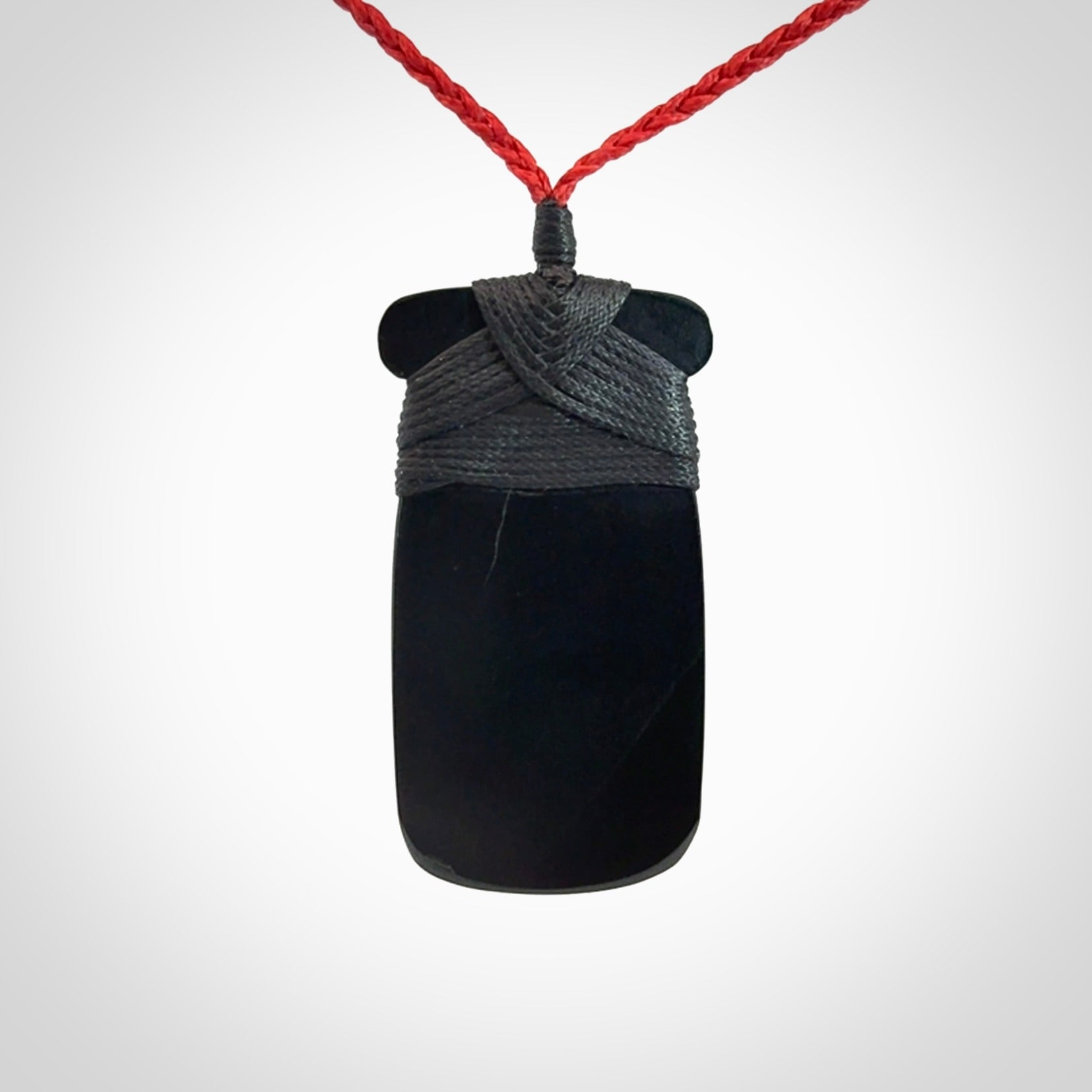 Hand carved black jade toki pendant. Made by NZ Pacific from Australian black jade. Black Jade Toki provided with adjustable cords and packaged in a woven kete pouch. Delivered with express courier.