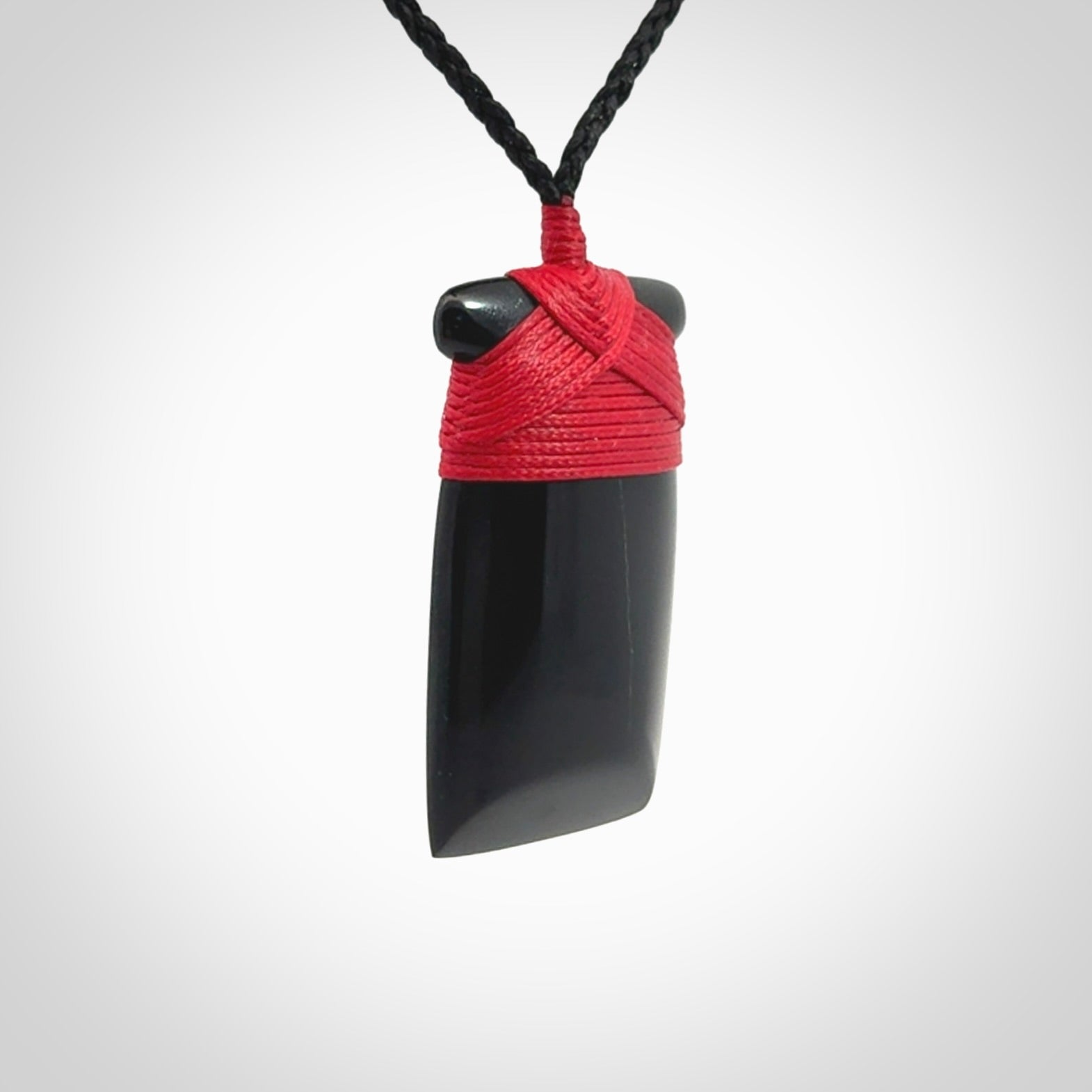 Hand carved black jade toki pendant. Made by NZ Pacific from Australian black jade. Black Jade Toki provided with adjustable cords and packaged in a woven kete pouch. Delivered with express courier.