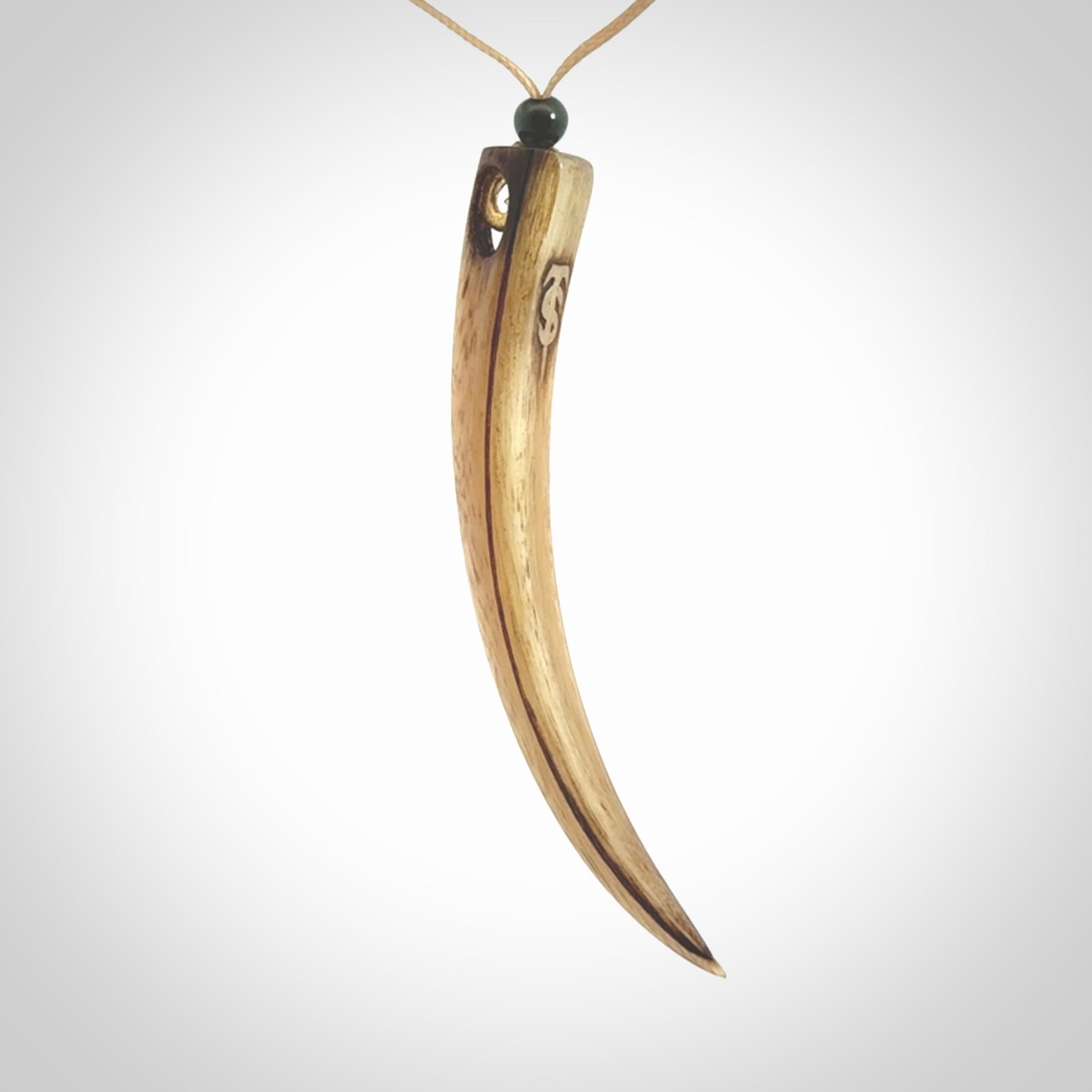 This is a hand carved rams horn huia bird beak pendant. It is made from rams horn with 24 carat gold leaf and jade toggle. This is a large sized necklace and is a very unique, one only, pendant that is a collectors piece. Hand carved by New Zealand artist, Sami.