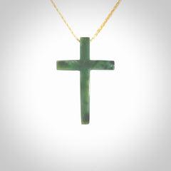 Hand carved jade cross. Made from New Zealand jade. Christian cross for sale online.This picture shows a green jade cross suspended on a fine, plaited cord. The cross is hand carved jade cross. Made from New Zealand jade. Christian cross for sale online.