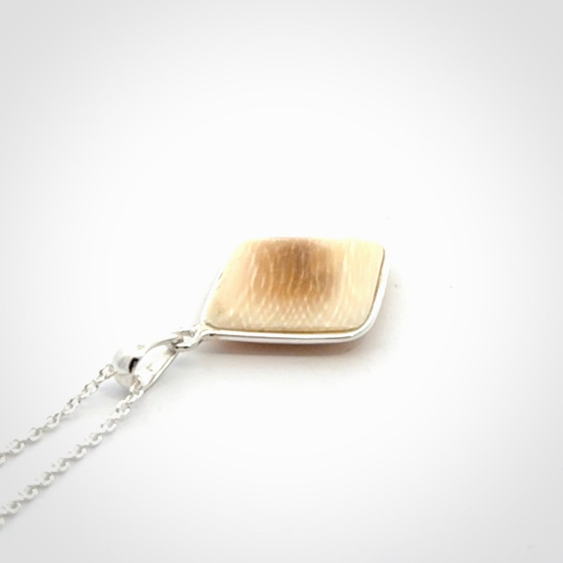 Hand carved mammoth tusk pendant. Hand made by NZ Pacific for sale online. Delivered with a sterling silver chain and packaged in a woven kete pouch.