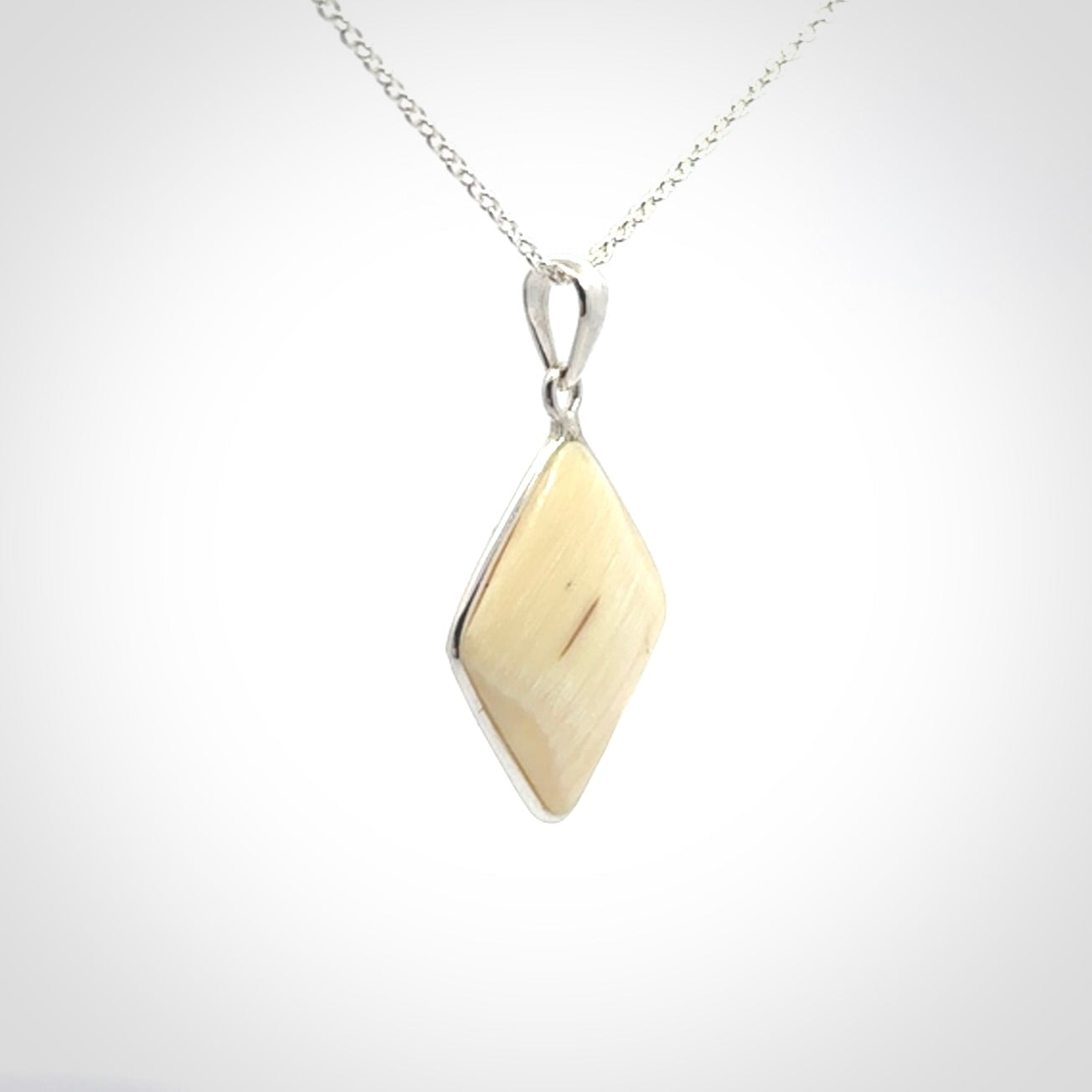 Hand carved mammoth tusk pendant. Hand made by NZ Pacific for sale online. Delivered with a sterling silver chain and packaged in a woven kete pouch.