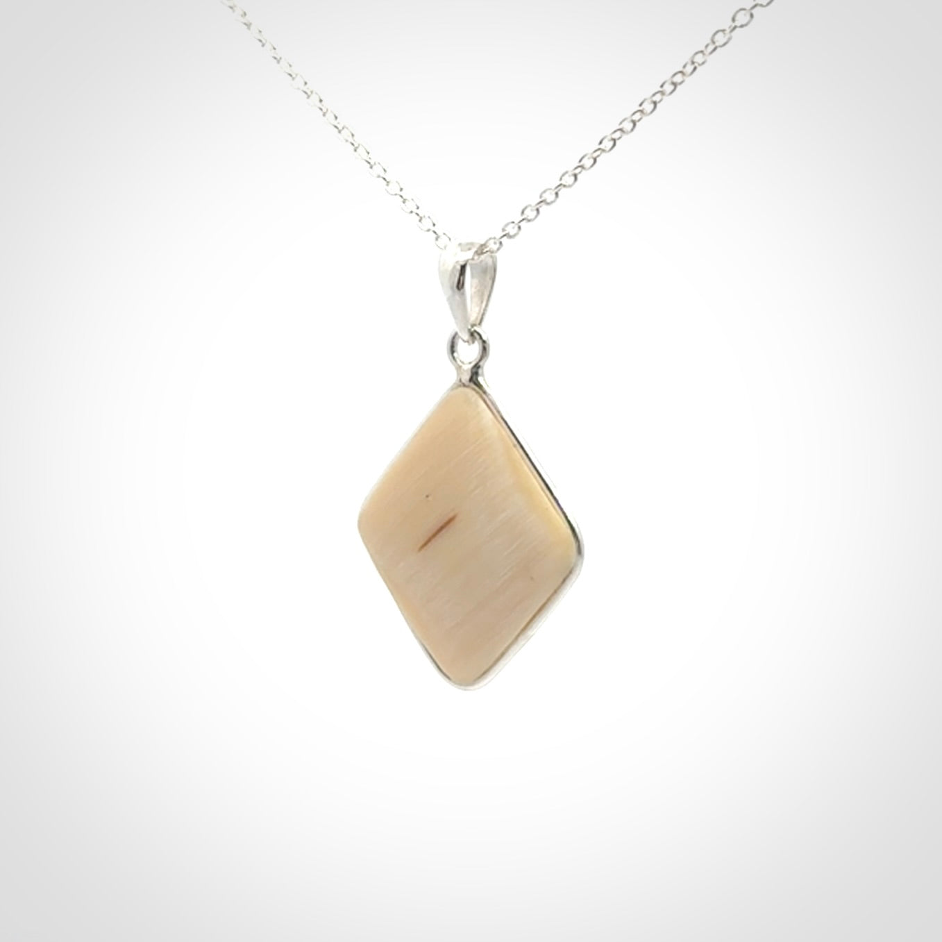 Hand carved mammoth tusk pendant. Hand made by NZ Pacific for sale online. Delivered with a sterling silver chain and packaged in a woven kete pouch.