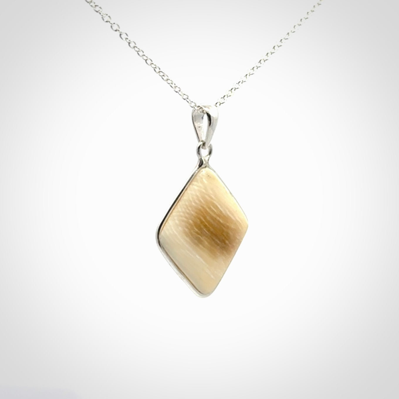 Hand carved mammoth tusk pendant. Hand made by NZ Pacific for sale online. Delivered with a sterling silver chain and packaged in a woven kete pouch.