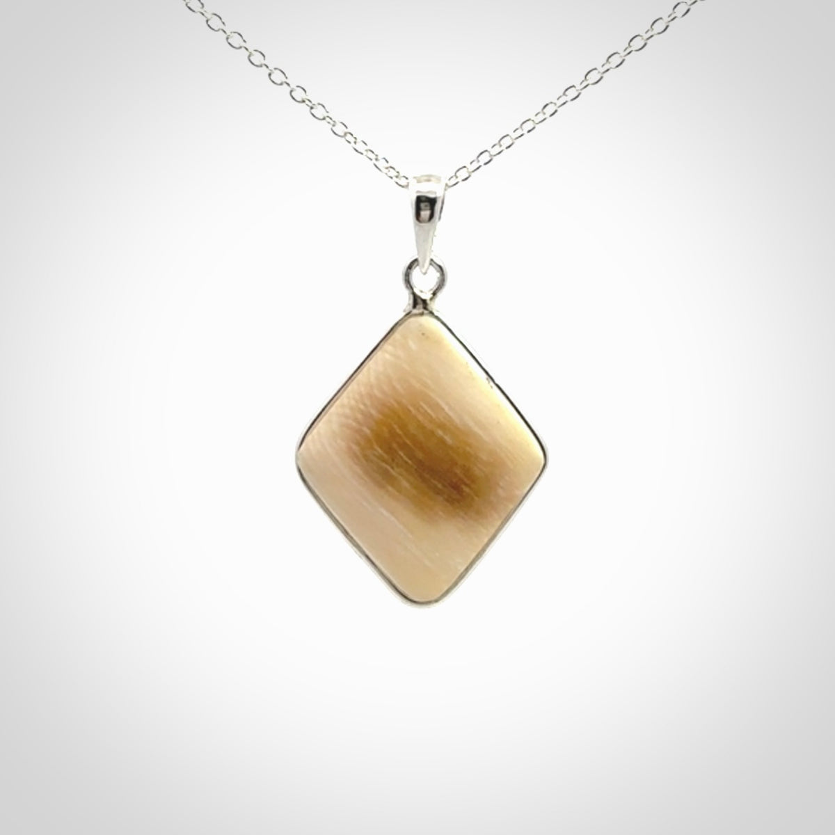 Hand carved mammoth tusk pendant. Hand made by NZ Pacific for sale online. Delivered with a sterling silver chain and packaged in a woven kete pouch.