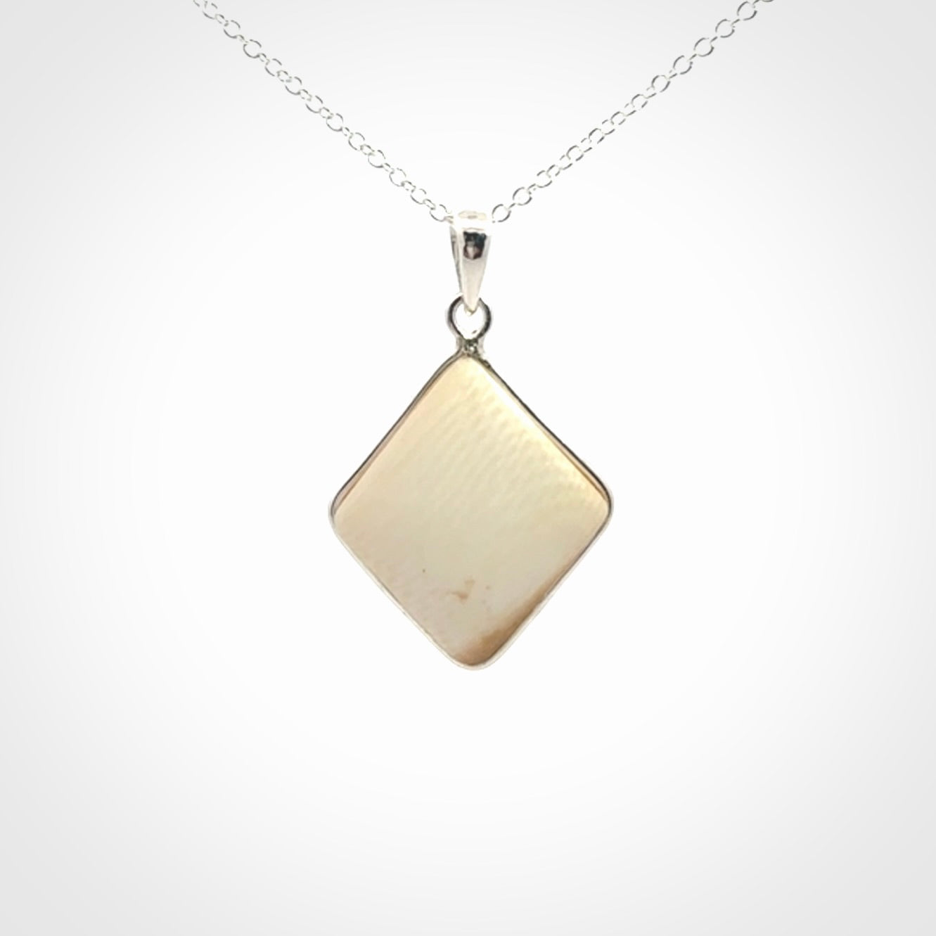 Hand carved mammoth tusk pendant. Hand made by NZ Pacific for sale online. Delivered with a sterling silver chain and packaged in a woven kete pouch.