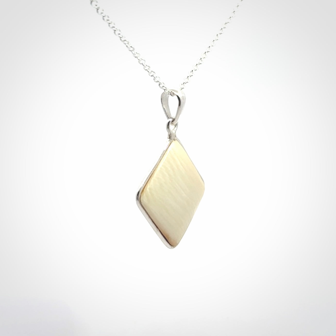Hand carved mammoth tusk pendant. Hand made by NZ Pacific for sale online. Delivered with a sterling silver chain and packaged in a woven kete pouch.