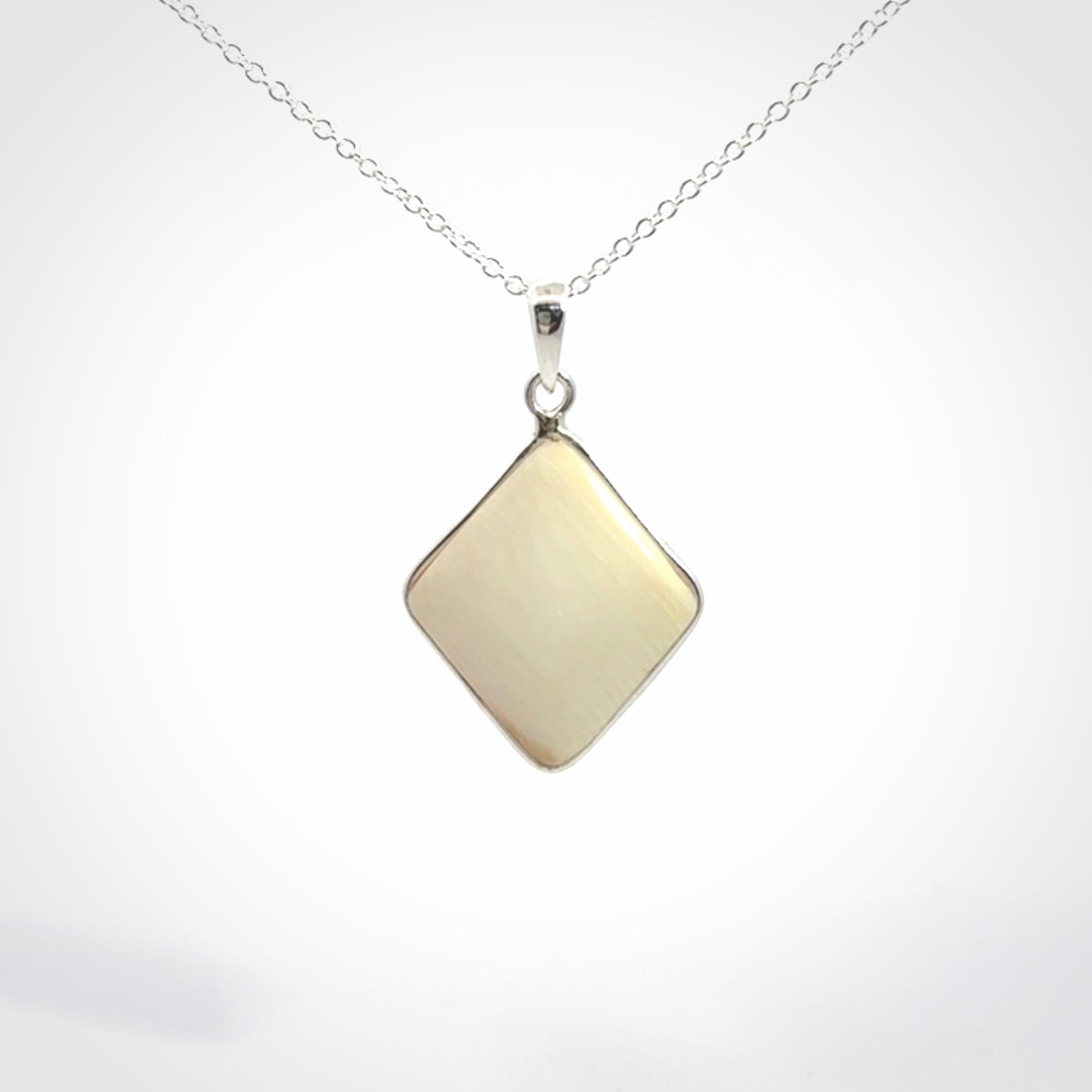 Hand carved mammoth tusk pendant. Hand made by NZ Pacific for sale online. Delivered with a sterling silver chain and packaged in a woven kete pouch.