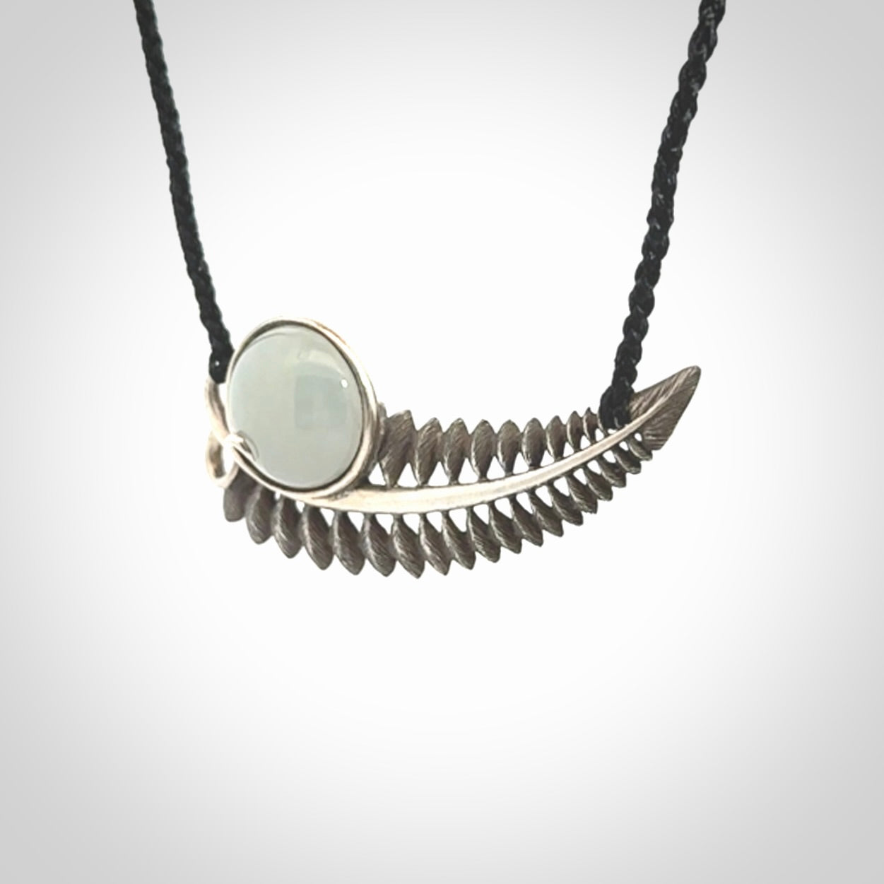 This is a hand carved Sterling Silver Fern leaf pendant with Siberian Jade insert. This is a medium sized necklace and is provided with an adjustable black cord.