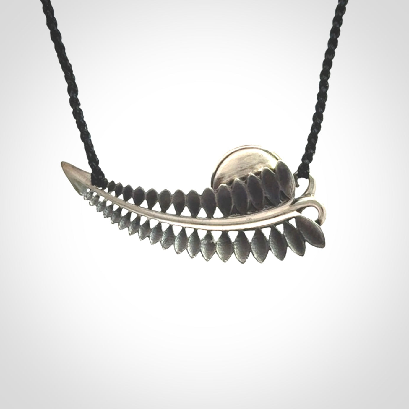 This is a hand carved Sterling Silver Fern leaf pendant with Siberian Jade insert. This is a medium sized necklace and is provided with an adjustable black cord.