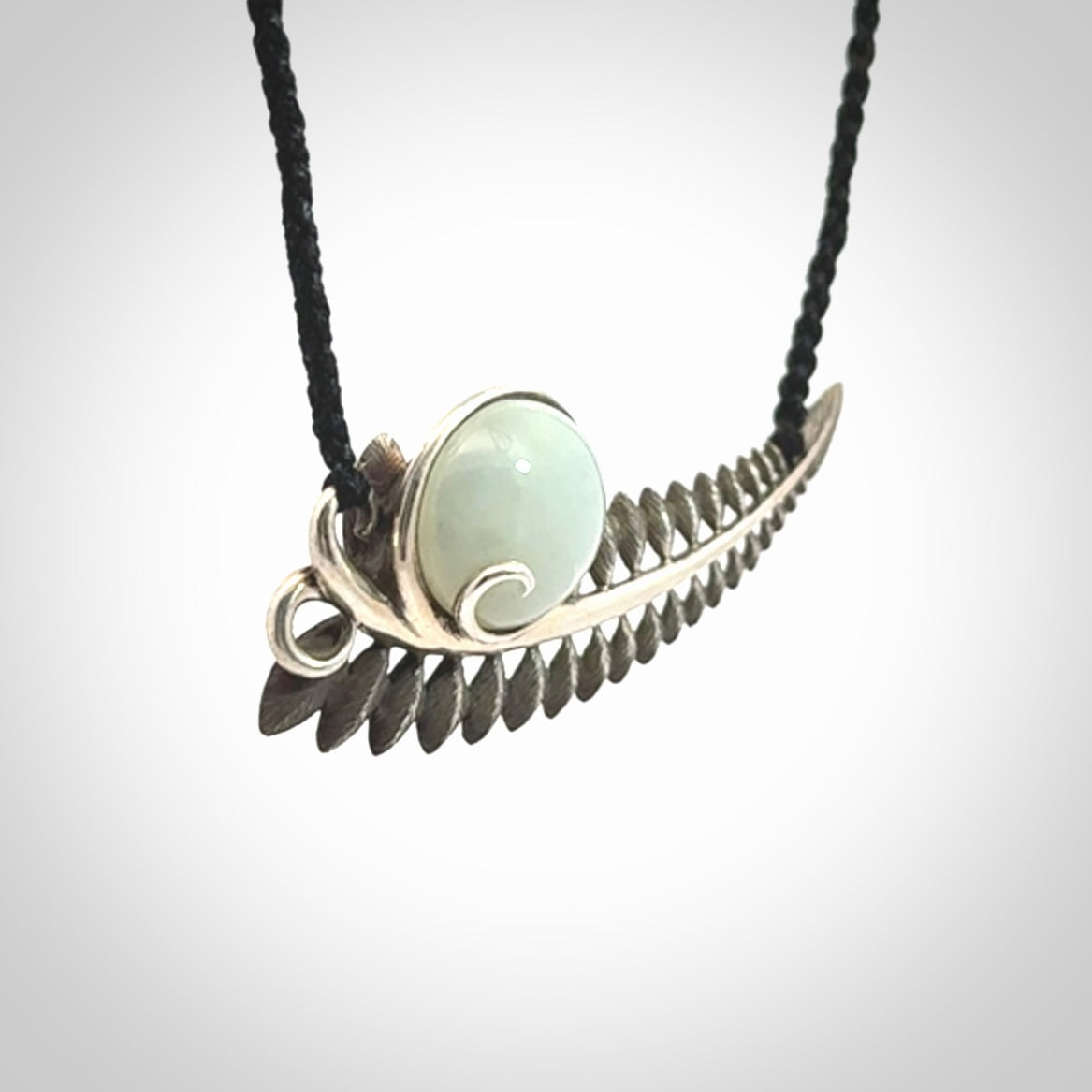 This is a hand carved Sterling Silver Fern leaf pendant with Siberian Jade insert. This is a medium sized necklace and is provided with an adjustable black cord.