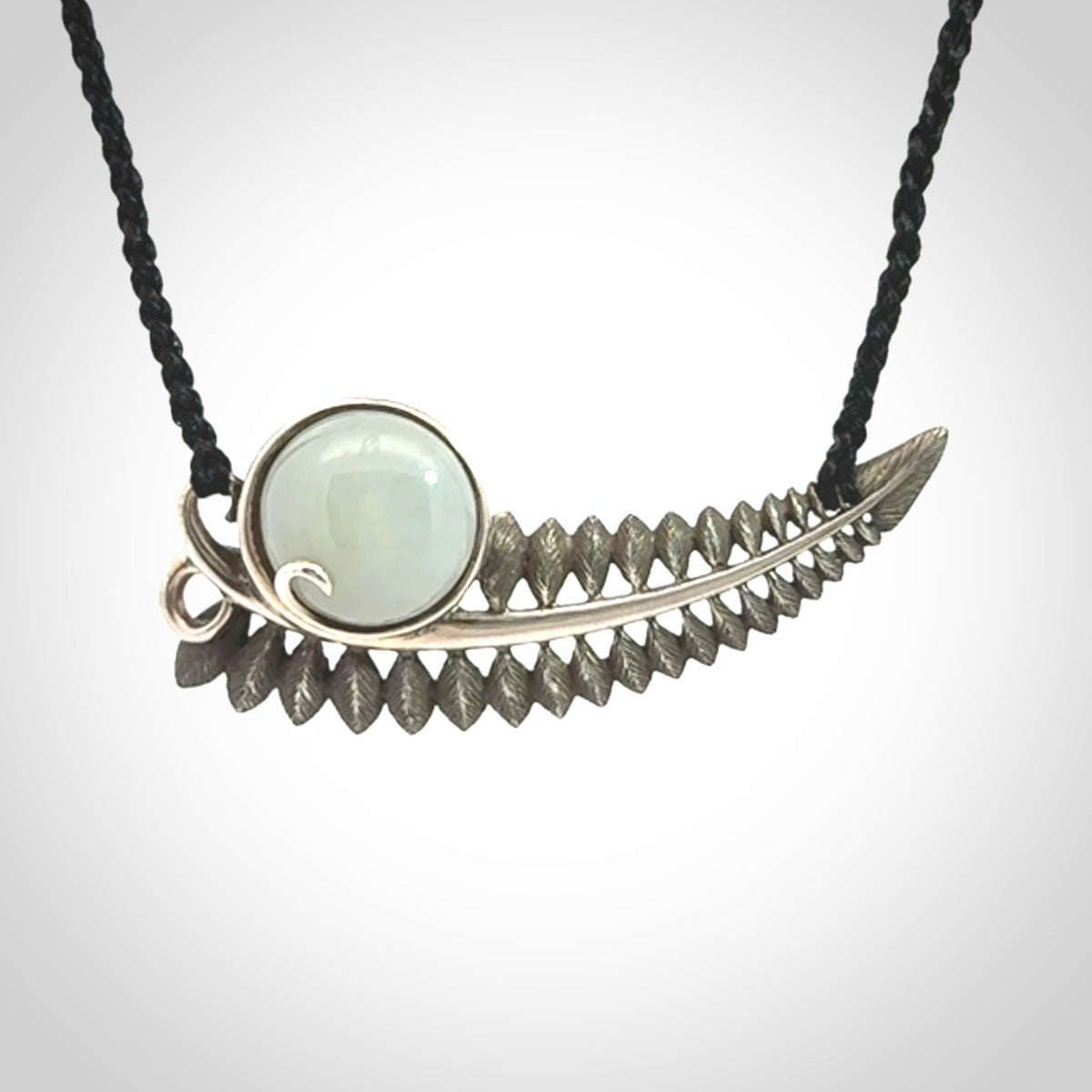 This is a hand carved Sterling Silver Fern leaf pendant with Siberian Jade insert. This is a medium sized necklace and is provided with an adjustable black cord.
