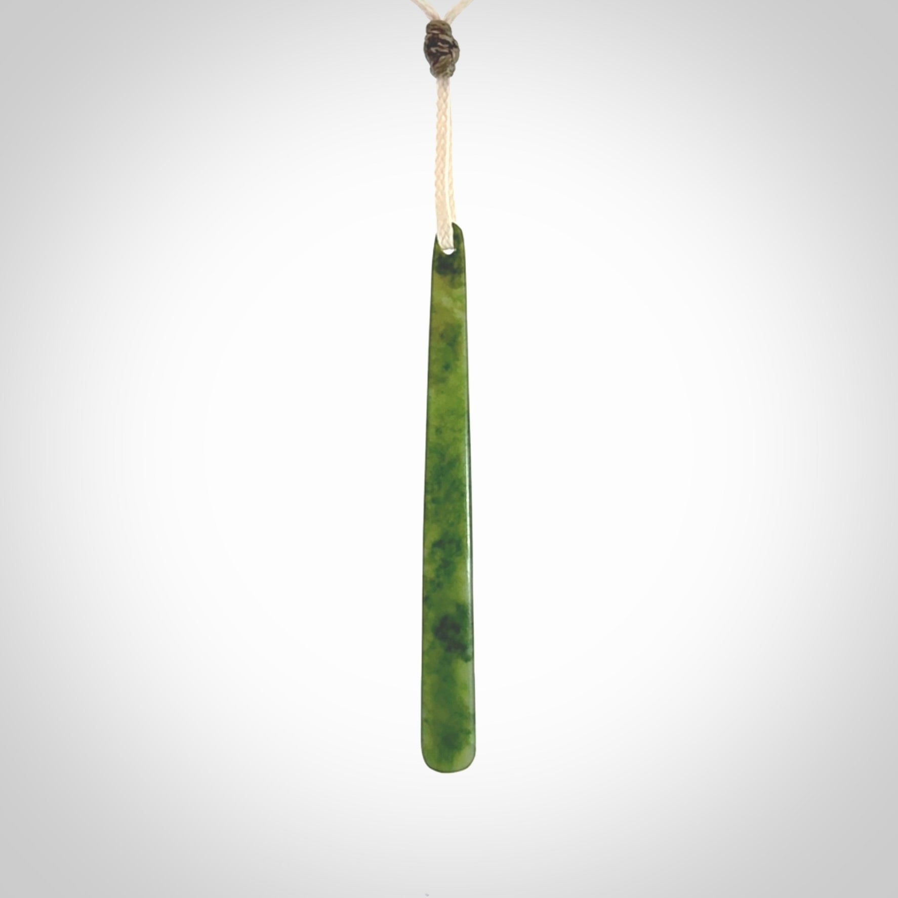 This picture shows a hand carved jade drop pendant by Ric Moor. The jade is a wonderful light, semi-translucent, green. It is suspended from a meringue coloured adjustable cord. Delivery is free worldwide.