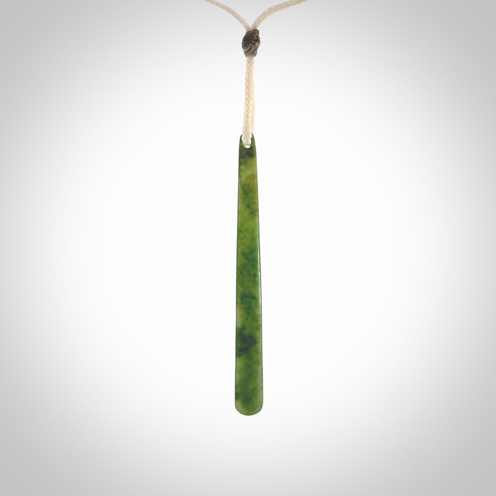 This picture shows a hand carved jade drop pendant by Ric Moor. The jade is a wonderful light, semi-translucent, green. It is suspended from a meringue coloured adjustable cord. Delivery is free worldwide.