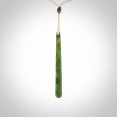 This picture shows a hand carved jade drop pendant by Ric Moor. The jade is a wonderful light, semi-translucent, green. It is suspended from a meringue coloured adjustable cord. Delivery is free worldwide.
