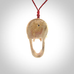 A hand carved SKULL pendant made from deer antler with Pyrope Garnet eyes. This is a work of art carved in deer antler, bone. We deliver this pendant to you on a plaited juicy red and passion red cord. Delivery with Express Courier is included in the price.
