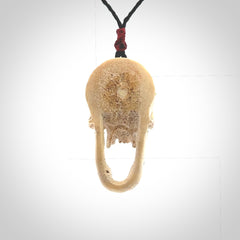 A hand carved SKULL pendant made from deer antler with Pyrope Garnet eyes. This is a work of art carved in deer antler, bone. We deliver this pendant to you on a plaited black cord. Delivery with Express Courier is included in the price.