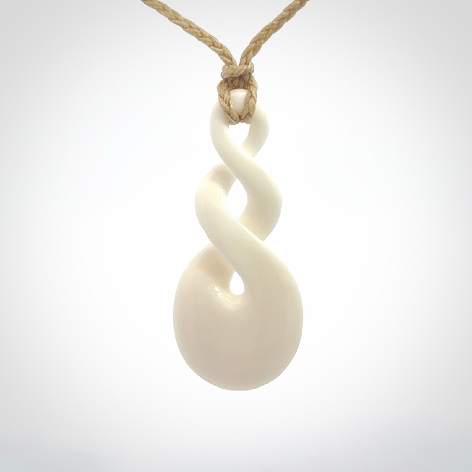 These are very cool, simple double twist pendants carved from natural bone. We have bound these in a adjustable cord and will ship them to you wherever you are. Hand carved by NZ Pacific.