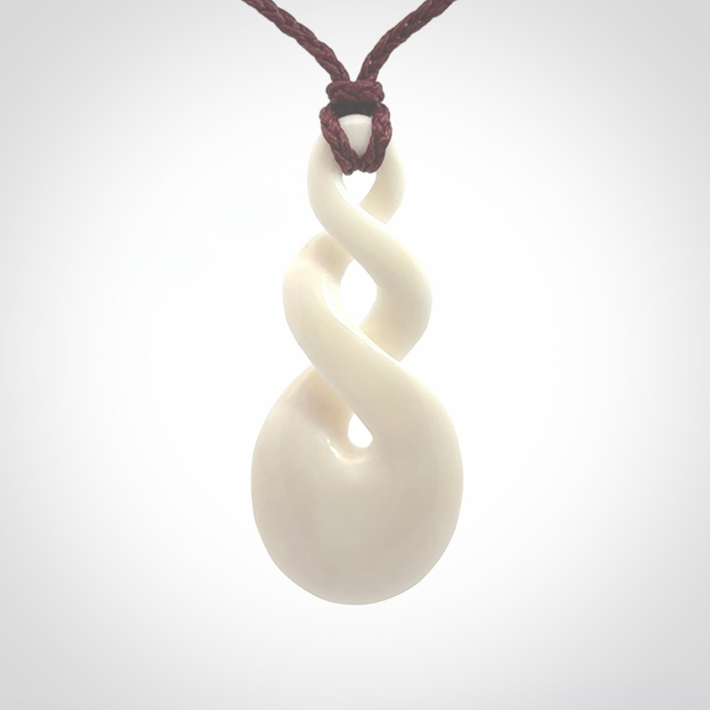 These are very cool, simple double twist pendants carved from natural bone. We have bound these in a adjustable cord and will ship them to you wherever you are. Hand carved by NZ Pacific.
