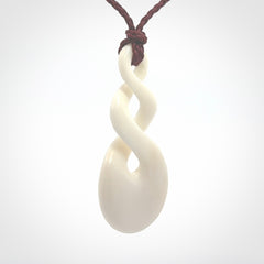 These are very cool, simple double twist pendants carved from natural bone. We have bound these in a adjustable cord and will ship them to you wherever you are. Hand carved by NZ Pacific.
