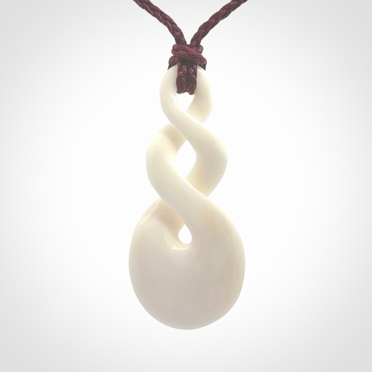 These are very cool, simple double twist pendants carved from natural bone. We have bound these in a adjustable cord and will ship them to you wherever you are. Hand carved by NZ Pacific.