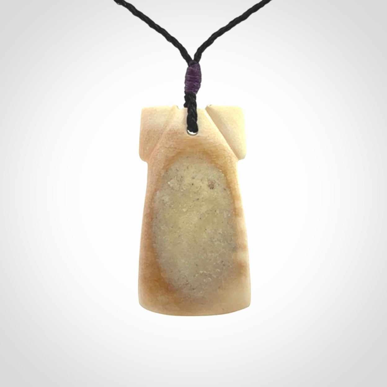 A stunning hand carved Woolly Mammoth Tusk Toki pendant. The toki has a small oval shaped piece of Pāua shell inset into the front face. This piece is bound with an adjustable cord. This is a little piece of Art to wear.
