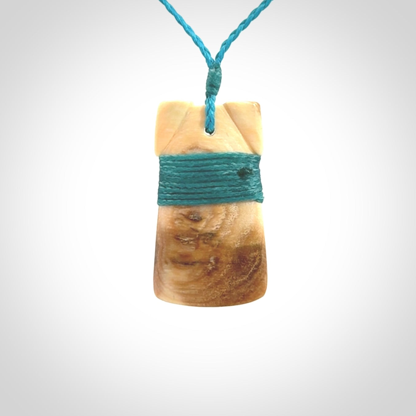 A stunning hand carved Woolly Mammoth Tusk Toki pendant. The toki has a small oval shaped piece of Pāua shell inset into the front face. This piece is bound with an adjustable cord. This is a little piece of Art to wear.
