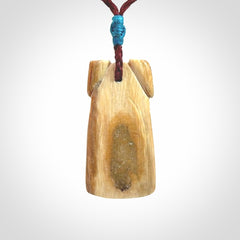 A stunning hand carved Woolly Mammoth Tusk Toki pendant. The toki has a small oval shaped piece of Pāua shell inset into the front face. This piece is bound with an adjustable cord. This is a little piece of Art to wear.