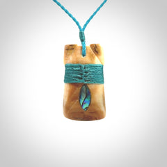 A stunning hand carved Woolly Mammoth Tusk Toki pendant. The toki has a small oval shaped piece of Pāua shell inset into the front face. This piece is bound with an adjustable cord. This is a little piece of Art to wear.