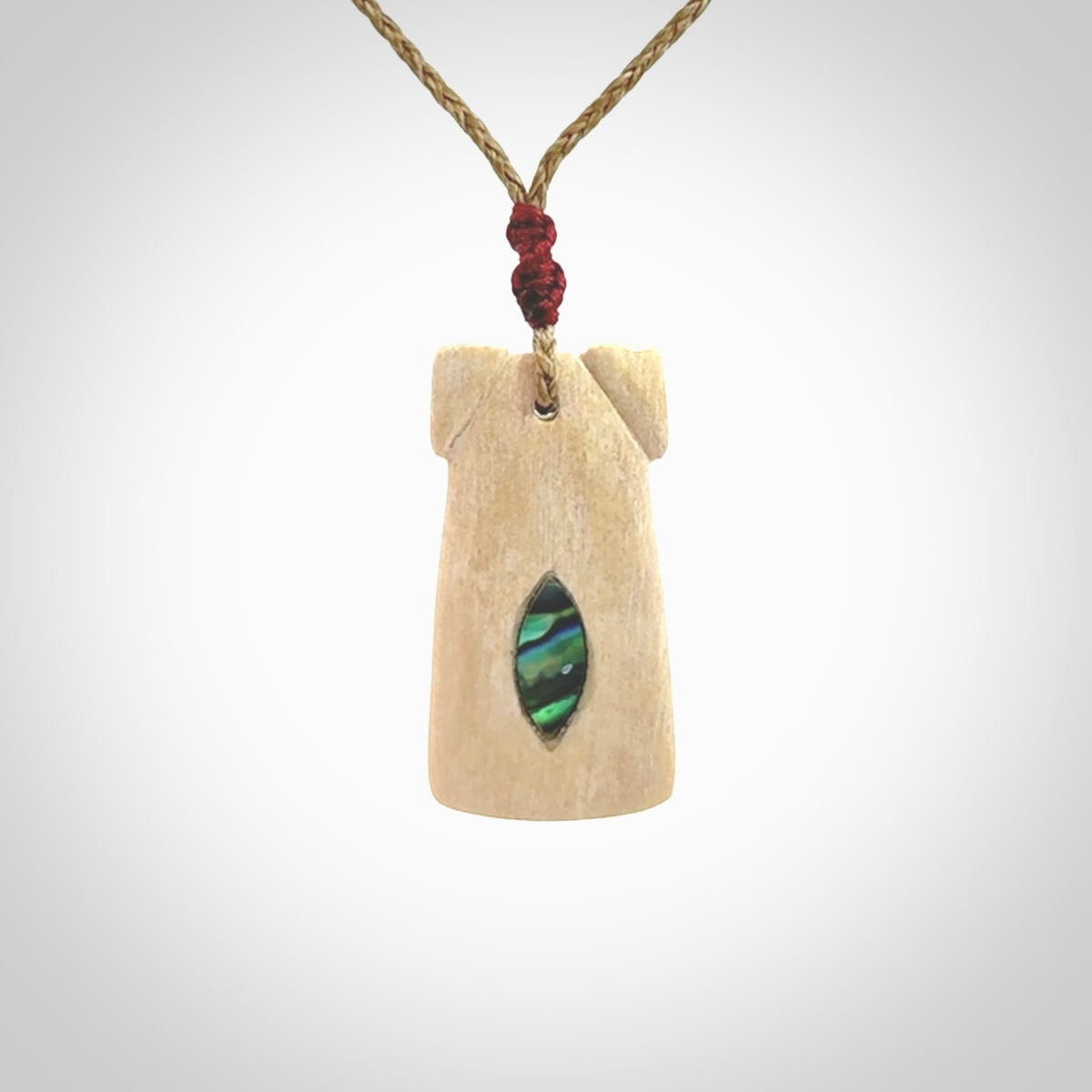 A stunning hand carved Woolly Mammoth Tusk Toki pendant. The toki has a small oval shaped piece of Pāua shell inset into the front face. This piece is bound with an adjustable cord. This is a little piece of Art to wear.
