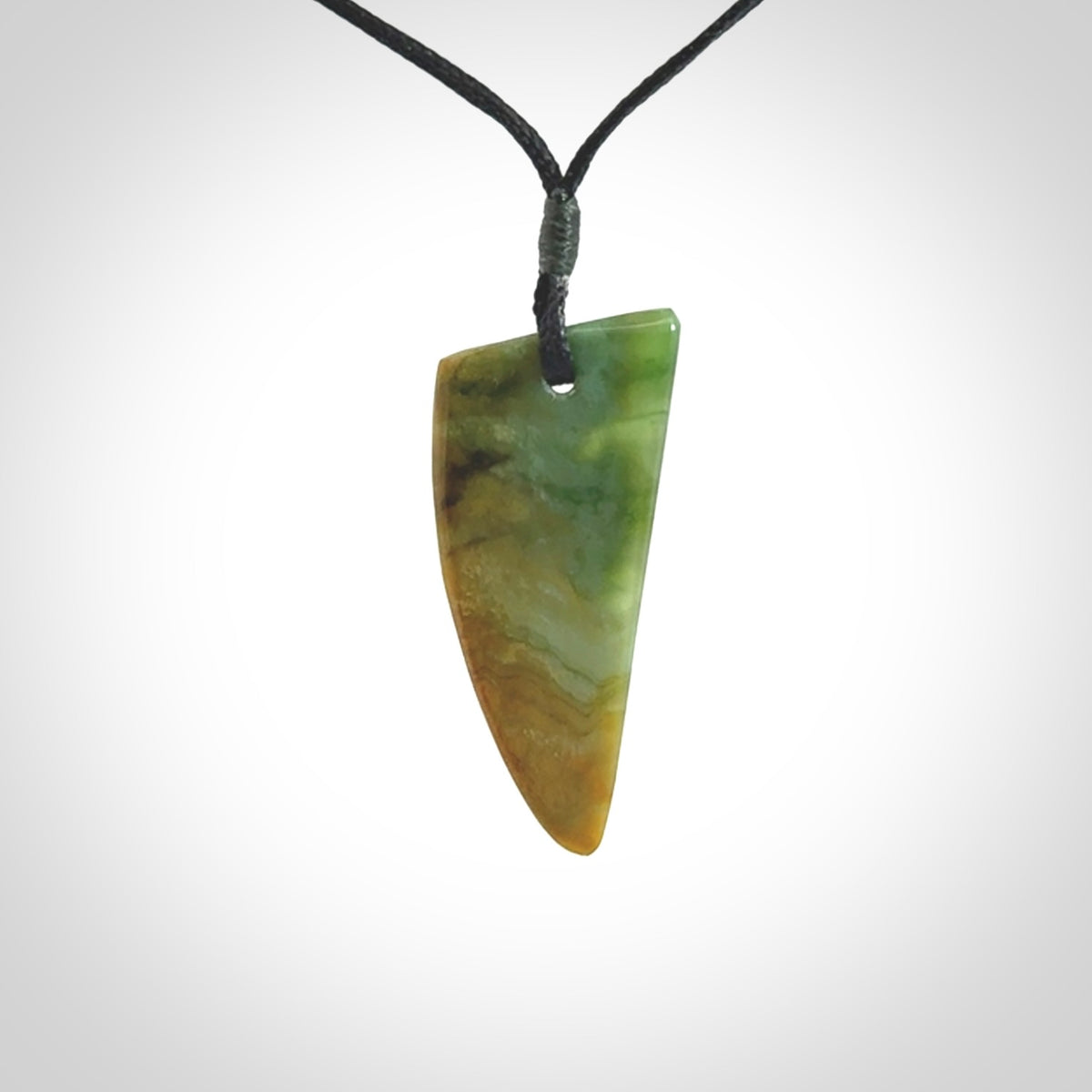 This photo shows a medium jade drop shaped pendant. It a a lovely varied green and orange New Zealand Marsden jade. The cord is black and is adjustable in length. One only medium, contemporary drop necklace from Jade.