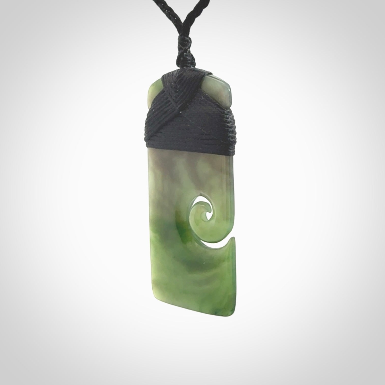 British Coloumbian jade toki koru pendant. Hand carved in New Zealand. Hand made British Coloumbian Jade jewellery. Provided with an adjustable cord and packaged in a woven kete pouch.