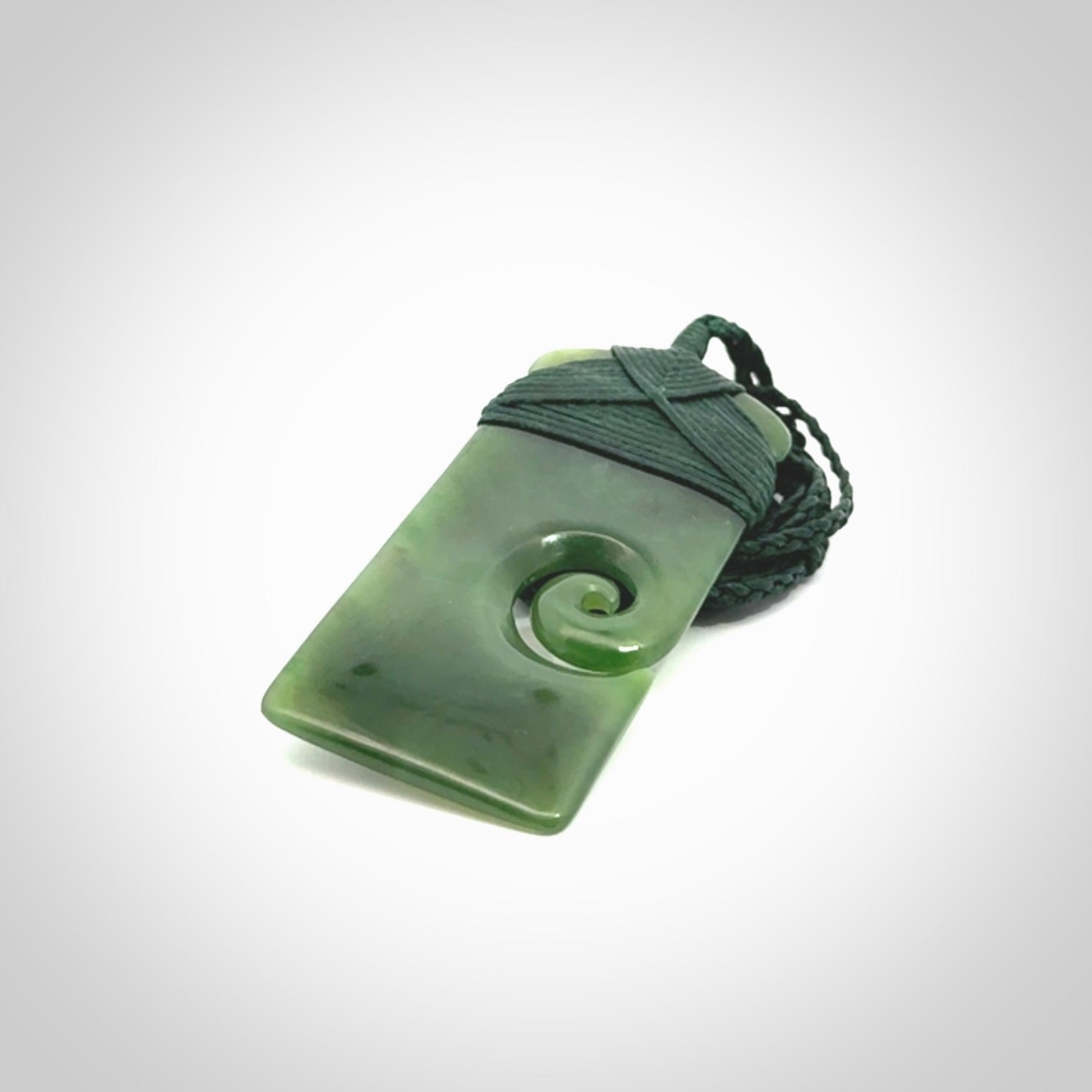 British Coloumbian jade toki koru pendant. Hand carved in New Zealand. Hand made British Coloumbian Jade jewellery. Provided with an adjustable cord and packaged in a woven kete pouch.