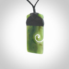 British Coloumbian jade toki koru pendant. Hand carved in New Zealand. Hand made British Coloumbian Jade jewellery. Provided with an adjustable cord and packaged in a woven kete pouch.