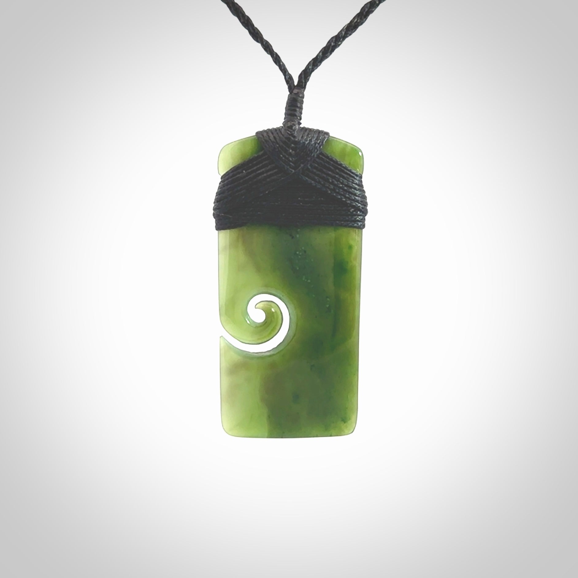 British Coloumbian jade toki koru pendant. Hand carved in New Zealand. Hand made British Coloumbian Jade jewellery. Provided with an adjustable cord and packaged in a woven kete pouch.
